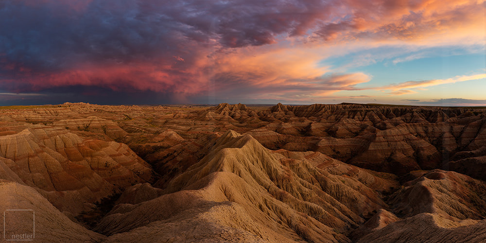 Bad Lands South Dakota at sunset with Pink Clouds over the Rugged Terrain